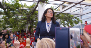 Photo of Rashida Tlaib looking off into the distance as she speaks to a crowd